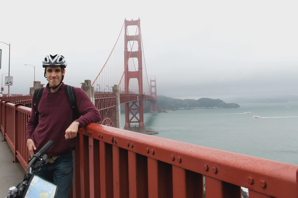 tourist-with-bike-helmet-in-front-of-golden-gate-bridge-cloudy.webp
